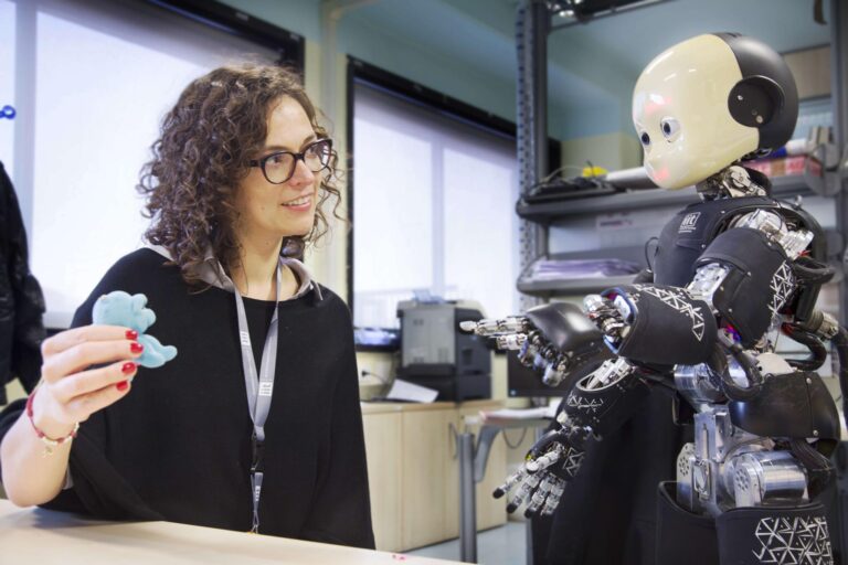 Agnieszka Wykowska sitting with iCub iit